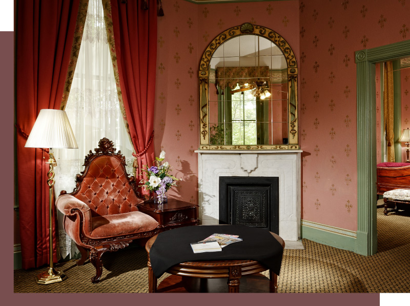 A beautiful window, plush armchair and fireplace in one of the Crescent's suites.